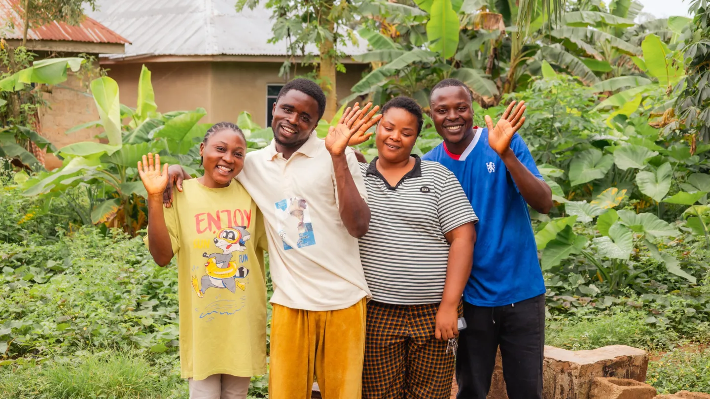 Four young adults stand together outdoors, smiling and waving at the camera. David Chukwuemeka is on the far right, pictured with other beneficiaries of the ILO’s ACCEL Africa project.