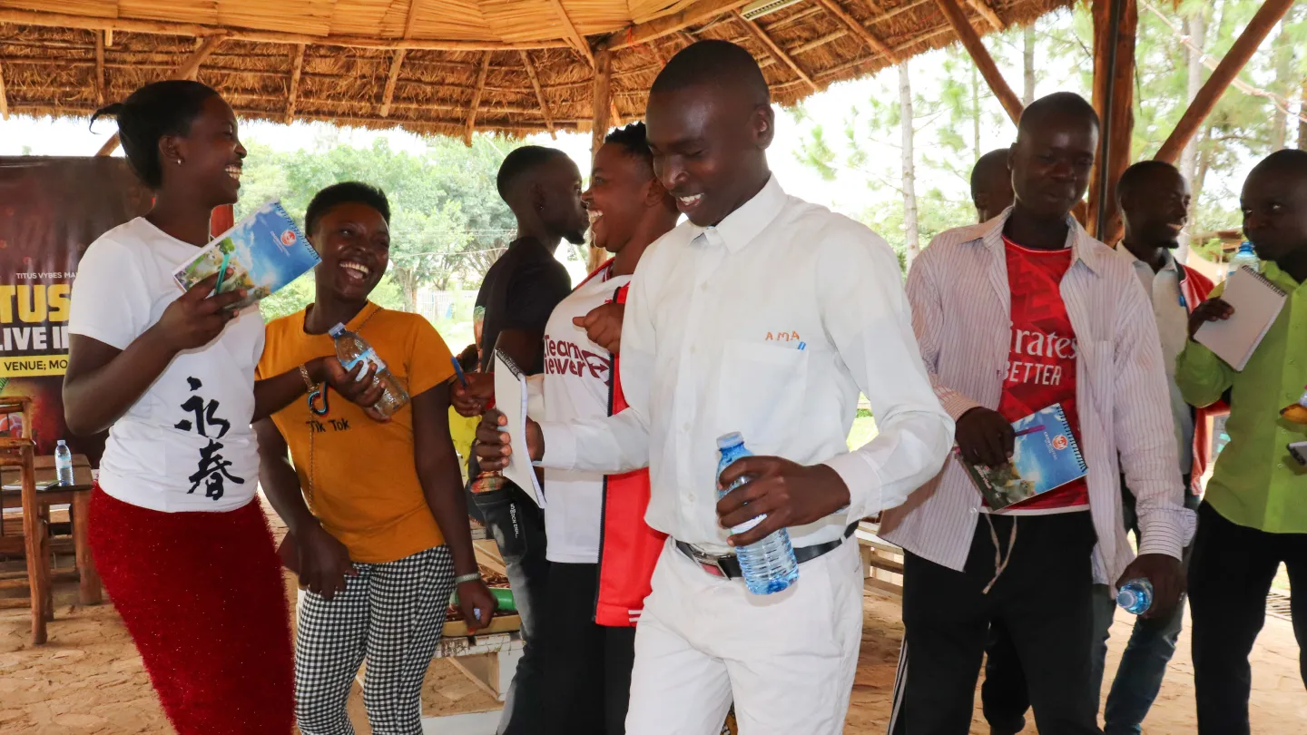 Emmanuel and other young participants laugh and dance together during a child labour hackathon in Eastern Uganda.