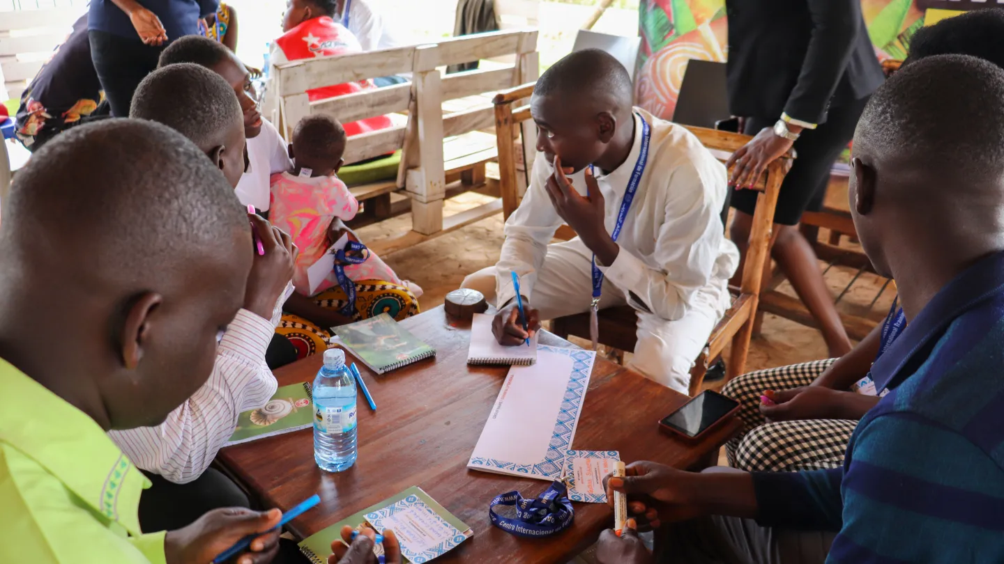 Emmanuel listens to his teammates and takes notes during a group discussion at the ACCEL Africa Hackathon in Mbale.