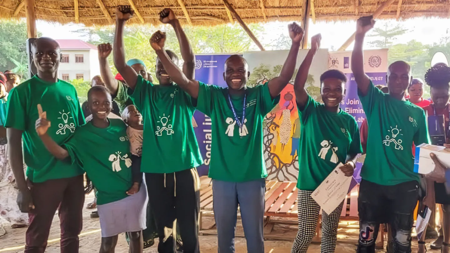 Emmanuel and his teammates raise their arms in celebration after winning at the Mbale child labour hackathon.