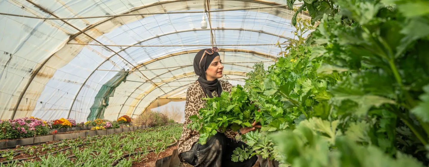Young lady in greenhouse in Jordan surrounded with plants