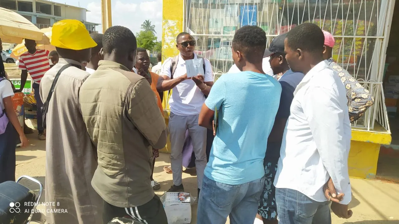 Group of young men gathered around ECOSIDA peer educator