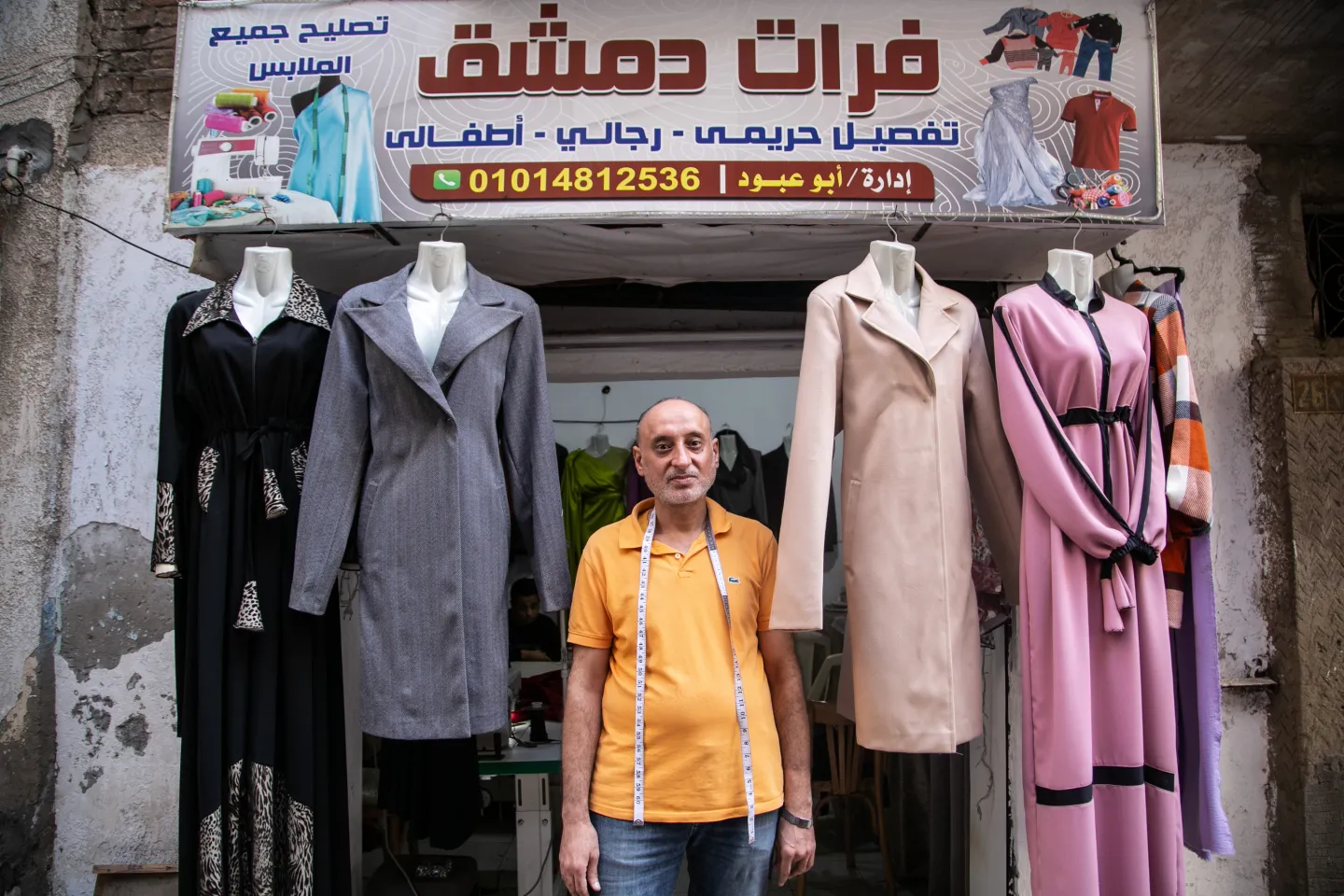 Syrian refugee in Egypt in front of his business