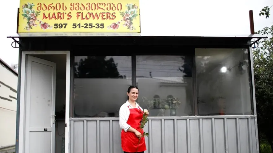 Woman from Giorgia in front of her flower shop in the center of Darcheli, Georgia