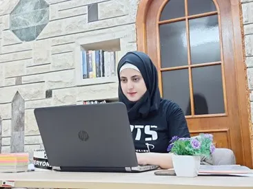 Woman from Iraq with her laptop participating in ILO’s Start Your Business training