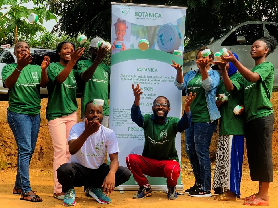 a Congolese refugee and his colleagues showing off the mosquito repellent product