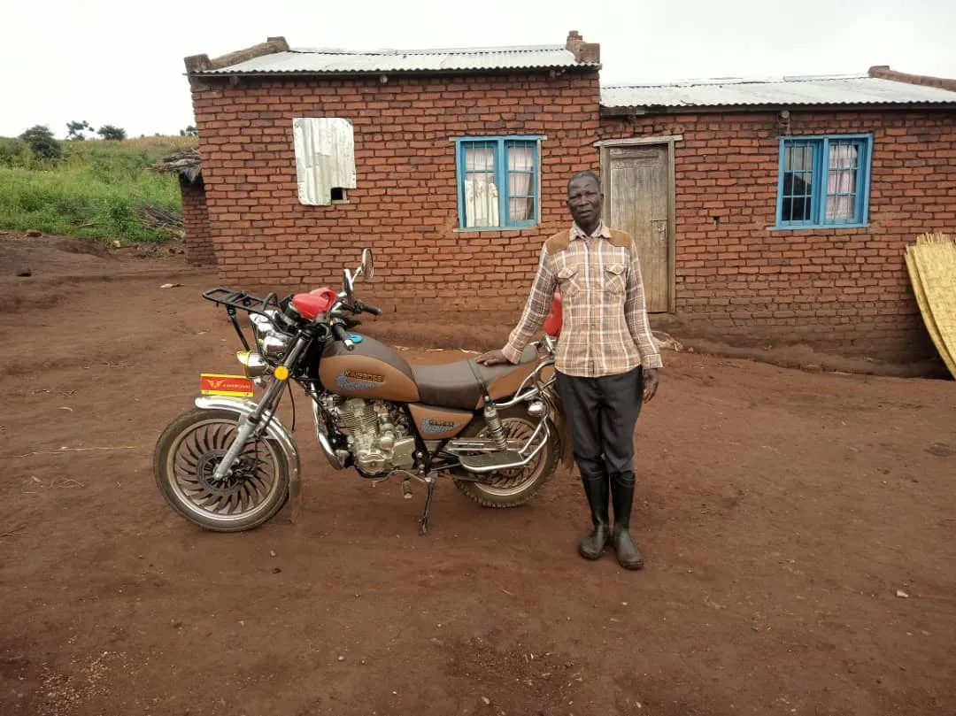 Ganizani stands next to his motorcycle