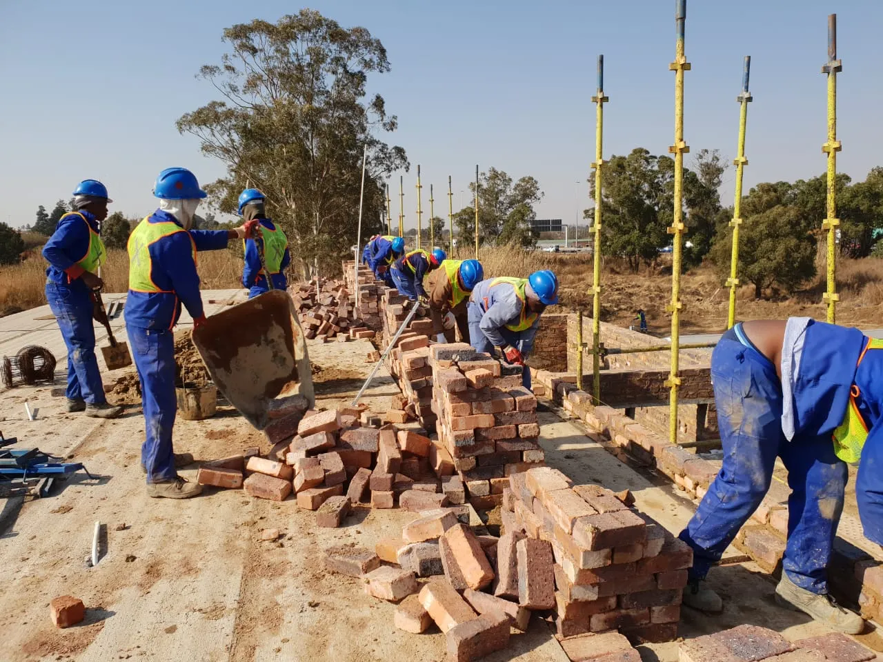 construction workers occupied on the foundation level with brick laying 