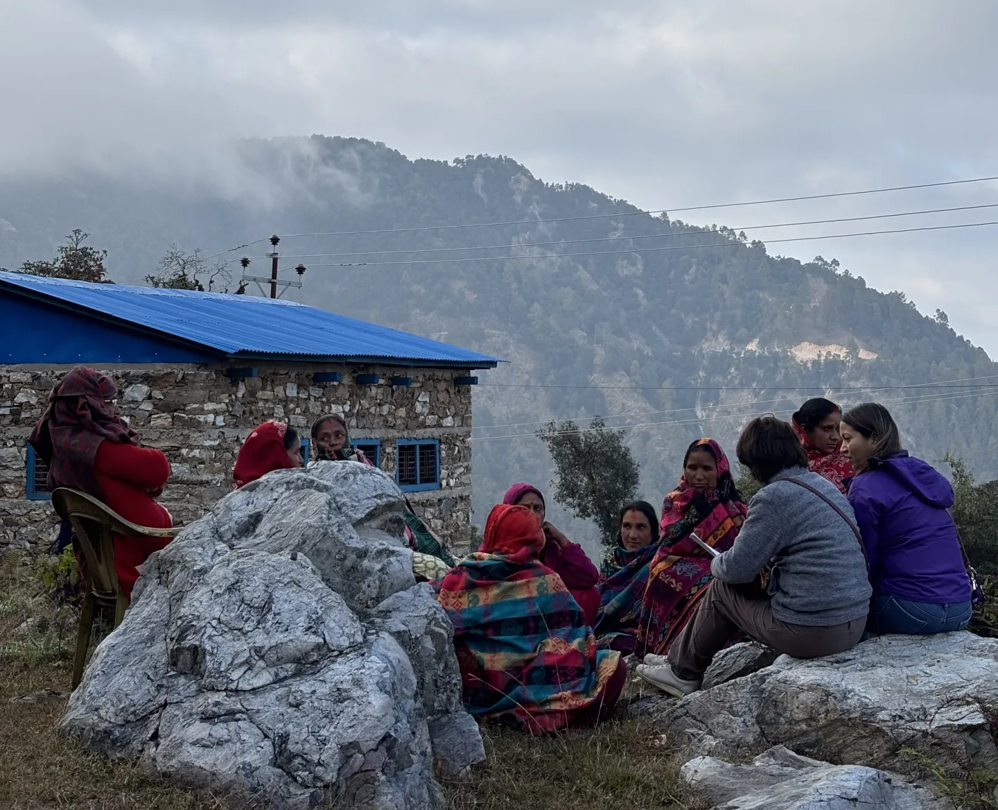 Women gathered for a Juenli Farmers Group meeting with Nepali mountains in the background.