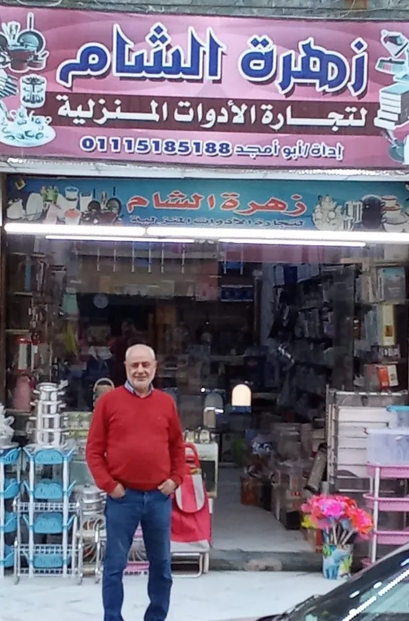 man in Egypt in front of small homeware shop 