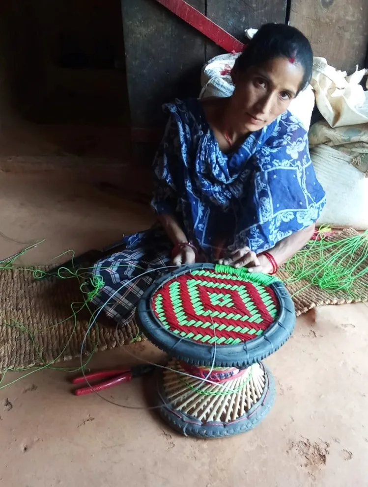 woman in Nepal weaving a bamboo stool