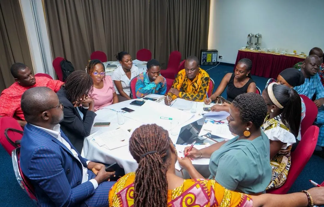 Participants exchanging ideas and taking notes during a policy dialogue meeting in Ghana