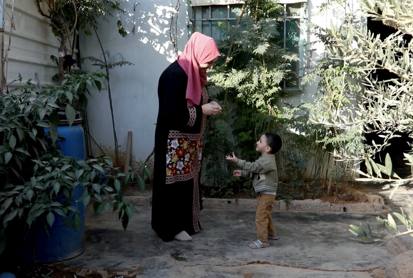 Tailor Hanan Khaled Al-Khawalda plays with her two-year-old son, Ahmad, in the patio of their home in Jordan’s Za’atari camp for Syrian refugees on October 28, 2025. 