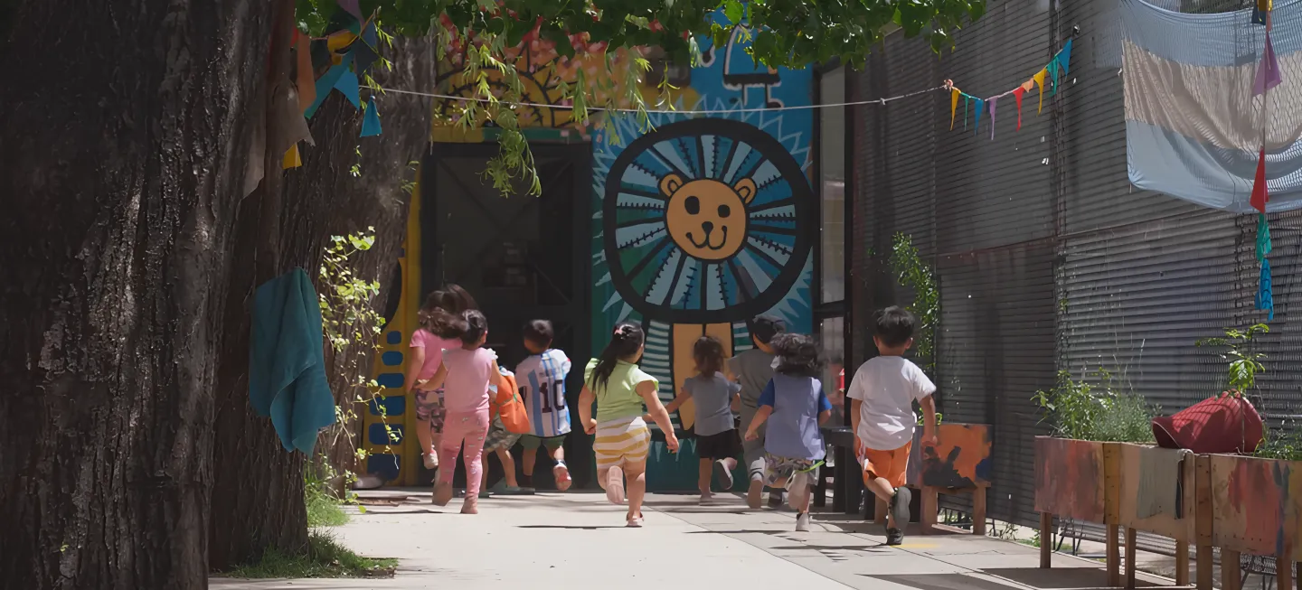 Children run toward the safety of the Early Childhood Space at La Carcova Popular Library, a vibrant sanctuary that reclaims their time from labour to provide a more dignified and peaceful childhood.