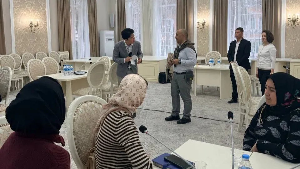 A facilitator engages with a participant during a role-play exercise as other employment counsellors observe in Fergana region, Uzbekistan