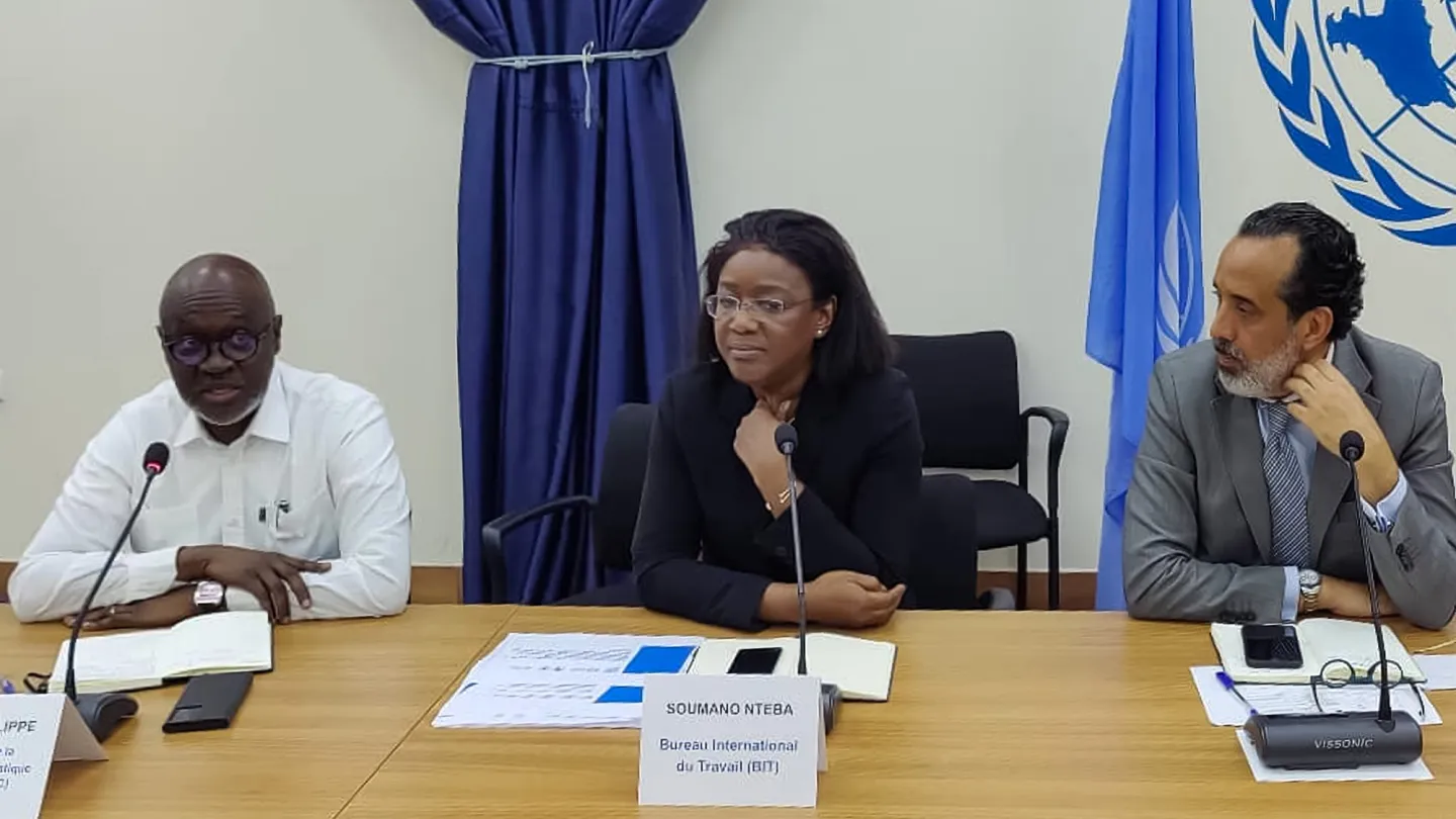 Nteba Soumano, Directrice du Bureau pays de l’OIT pour la République démocratique du Congo, intervient lors de la séance, assise à une table aux côtés d’autres intervenants, avec le drapeau des Nations Unies en arrière-plan.