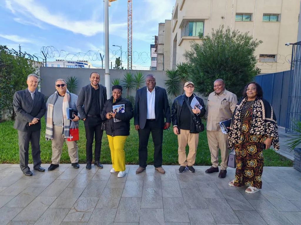 Photo de groupe devant un bâtiment.