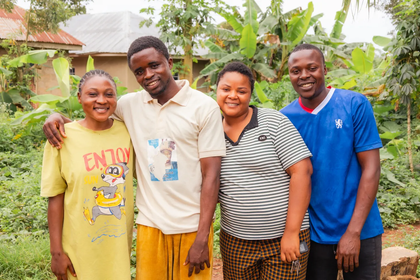 A young Nigerian man, Orifa Taiwo, stands with three other young adults from his village, all beneficiaries of the ILO’s ACCEL Africa project, smiling outdoors in a rural setting in Ondo State, Nigeria.