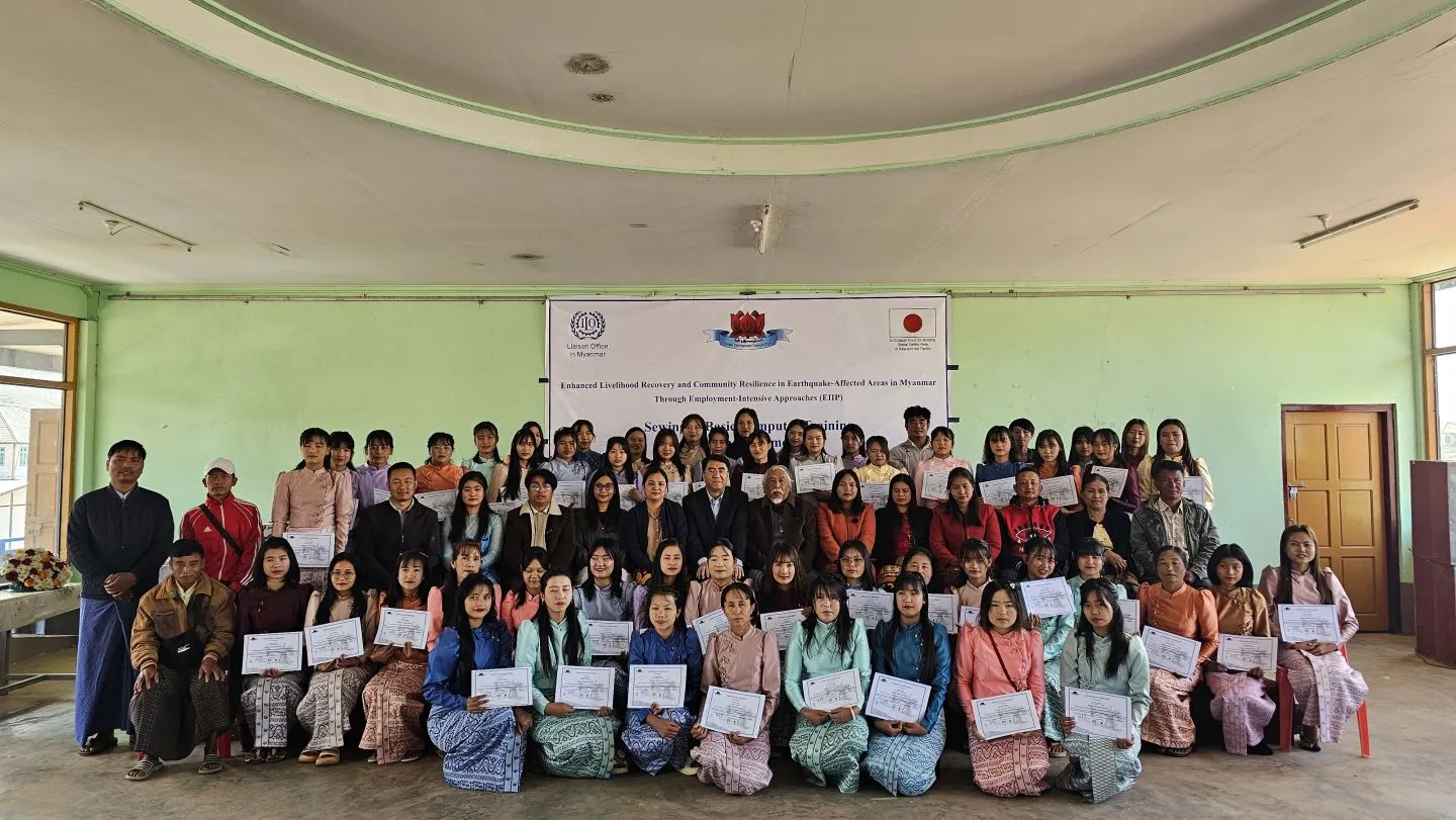 Group photo of around 60 training participants holding certificates together with ILO officials.