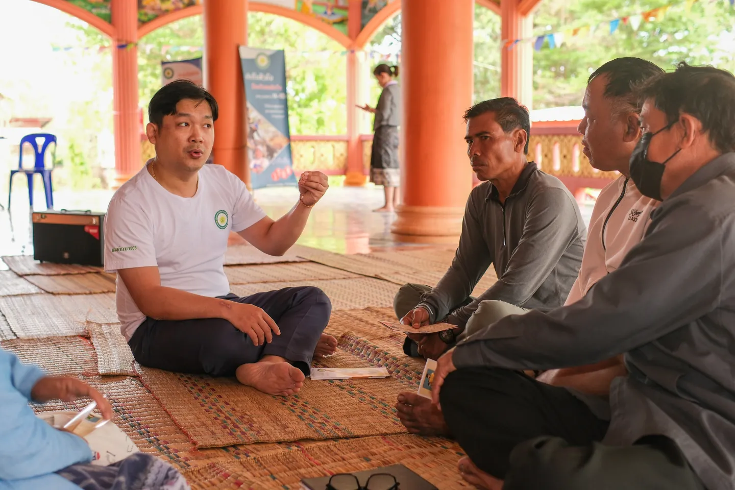 Four people seated on the floor during a discussion.
