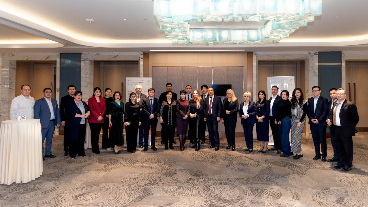 Group of participants posing after a roundtable in Tashkent
