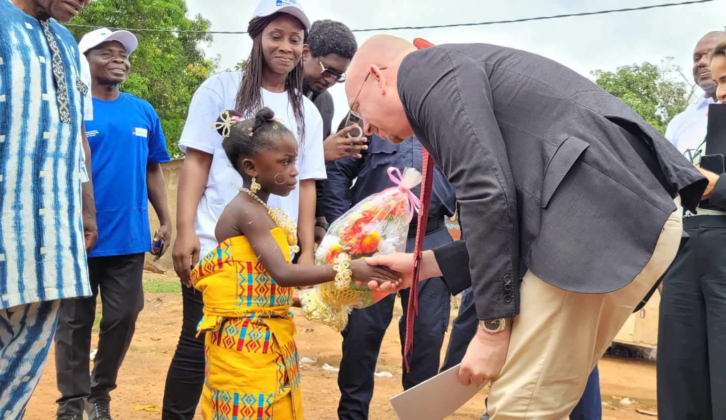 A girl child offers flowers to the Ambassador of the Netherlands on his visit to Soubre, Cote d'Ivoire
