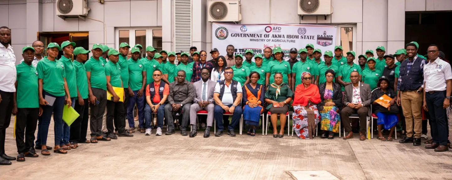 Large group photo of about 40 men and women posing outside a government building.