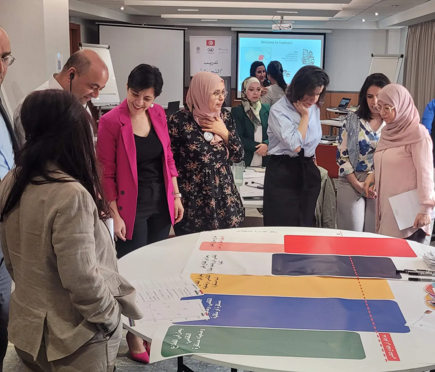 Participants gather around a visual mapping tool to analyze social protection frameworks. This exercise allowed the participants to visualize how different policy building blocks interact to form a cohesive SP system. Tunis, Tunisia. May 2025.