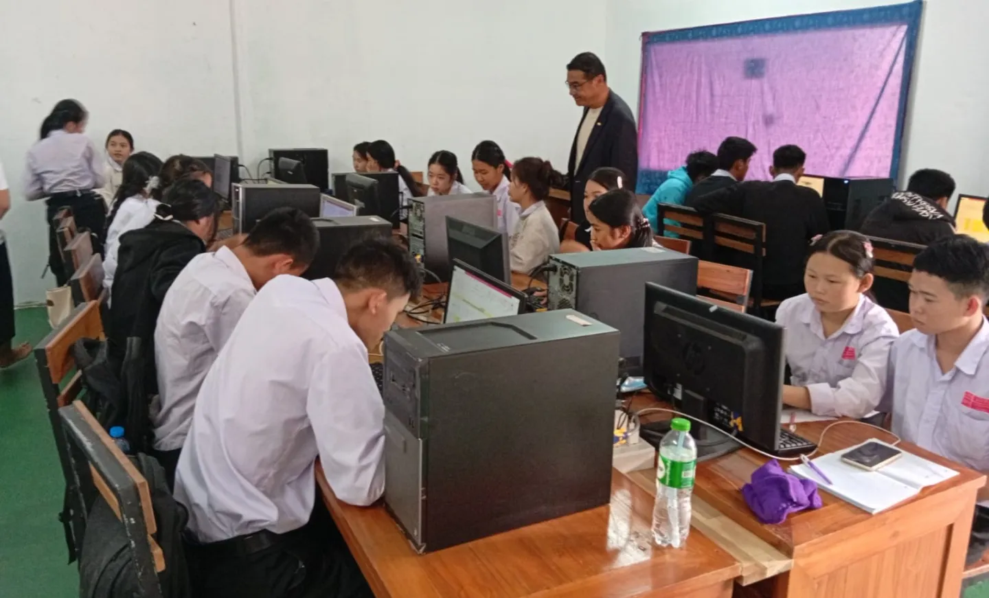 Students are seating in a classroom. 