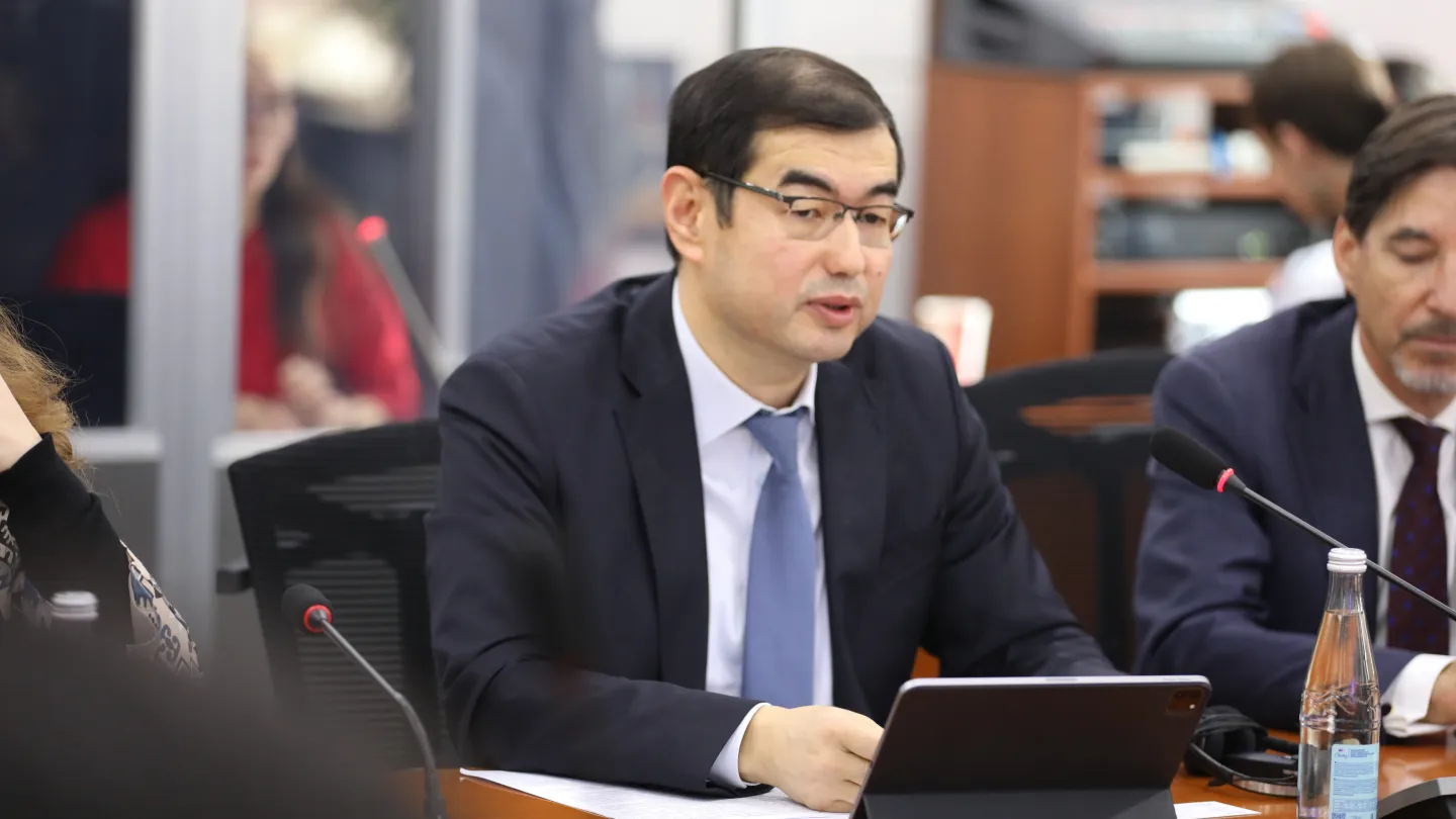 A man in business suit speaking into a mic