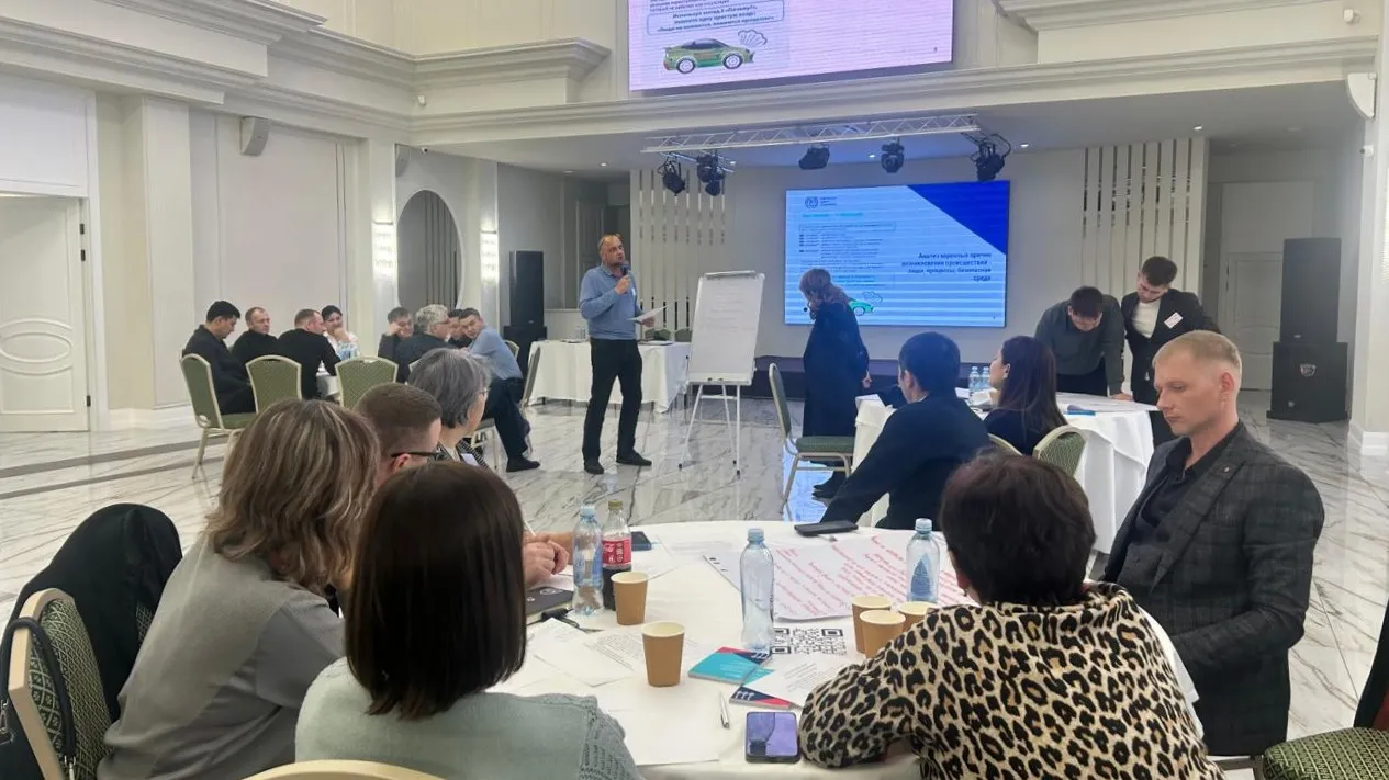 Group training session with participants seated at tables and a speaker at the front