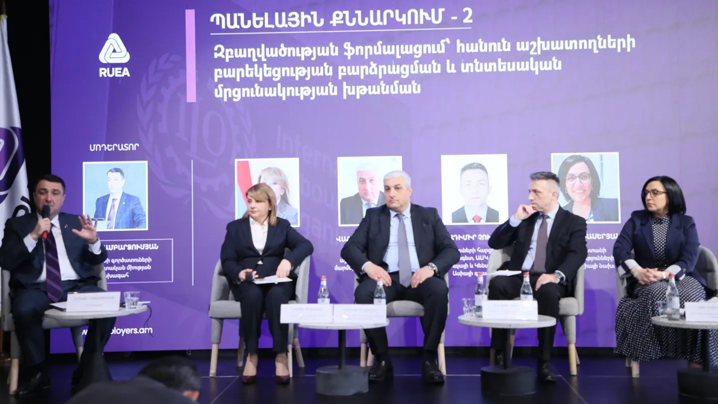 A panel discussion with five people seated on stage