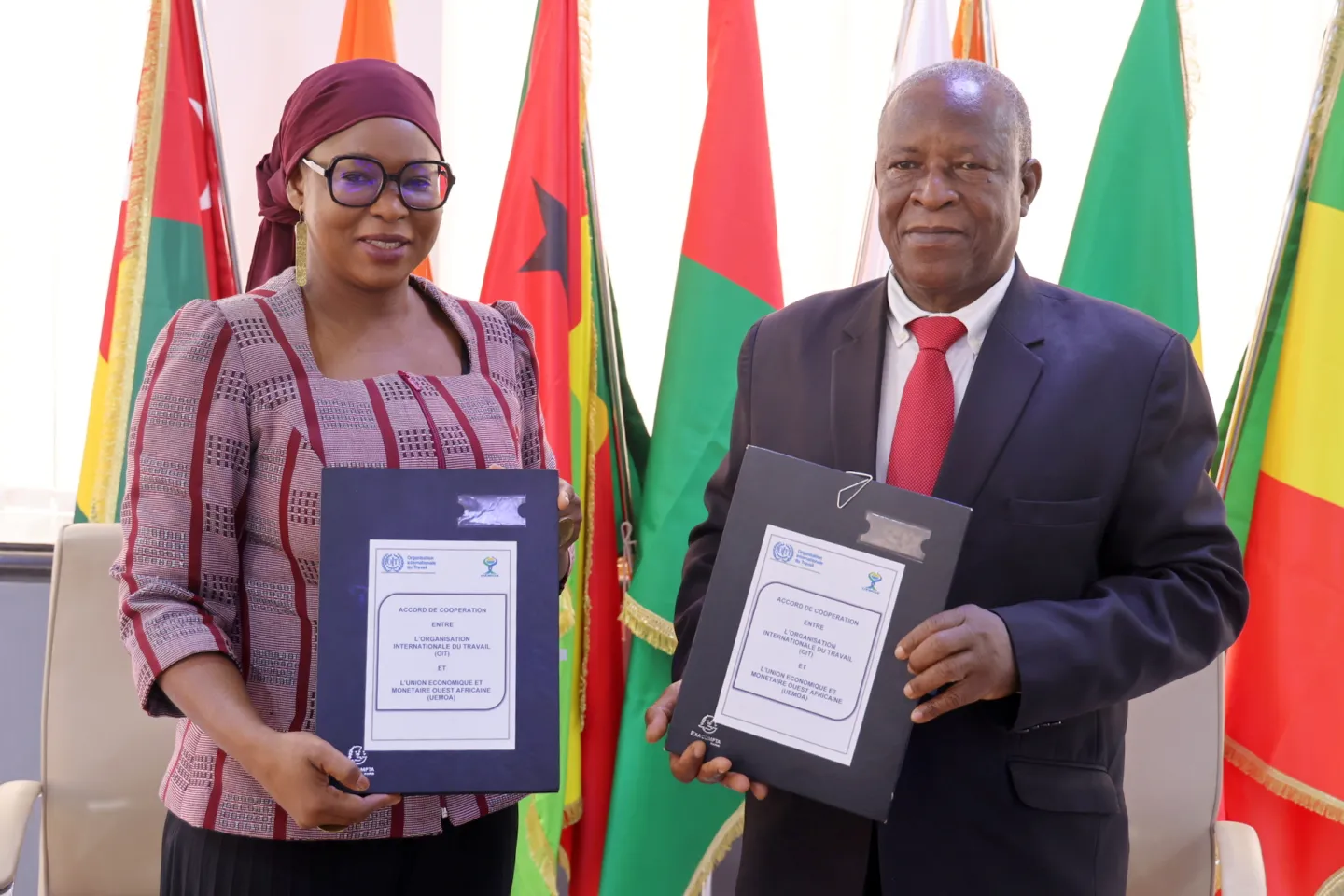 Ndeye Coumba Diop, Directrice du Bureau pays de l’OIT-Abidjan, et Michel Filiga Sawadogo, assurant l’intérim du Président de la Commission de l’UEMOA, présentant les parapheurs du protocole d’accord signé. 