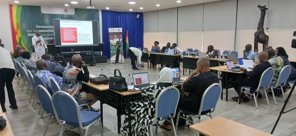 Salle de formation avec des participants assis autour de tables