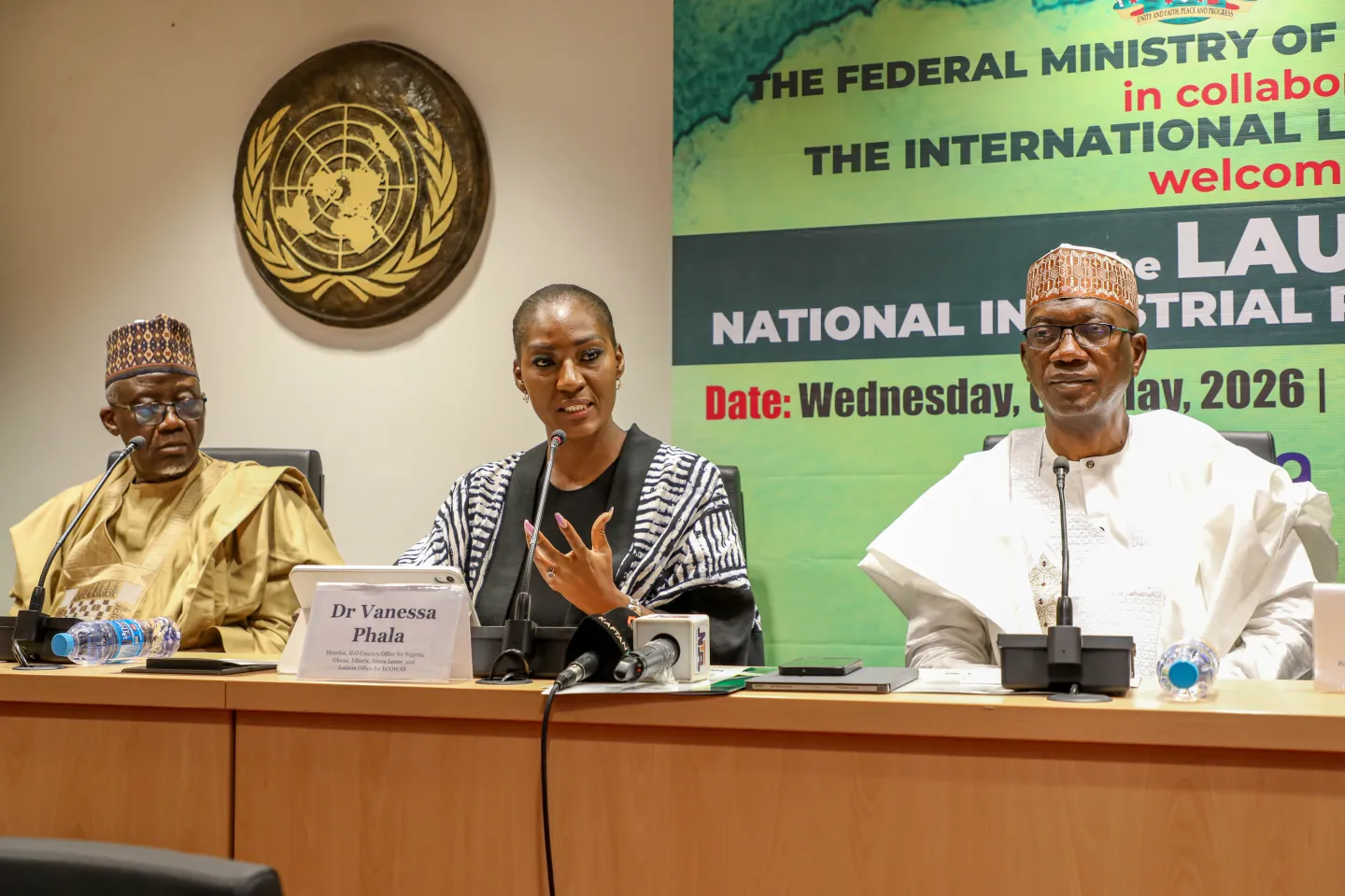 Dr Vanessa Phala addresses participants during a panel session at the launch of the National Industrial Relations Policy, with senior government officials seated alongside her beneath the United Nations emblem.