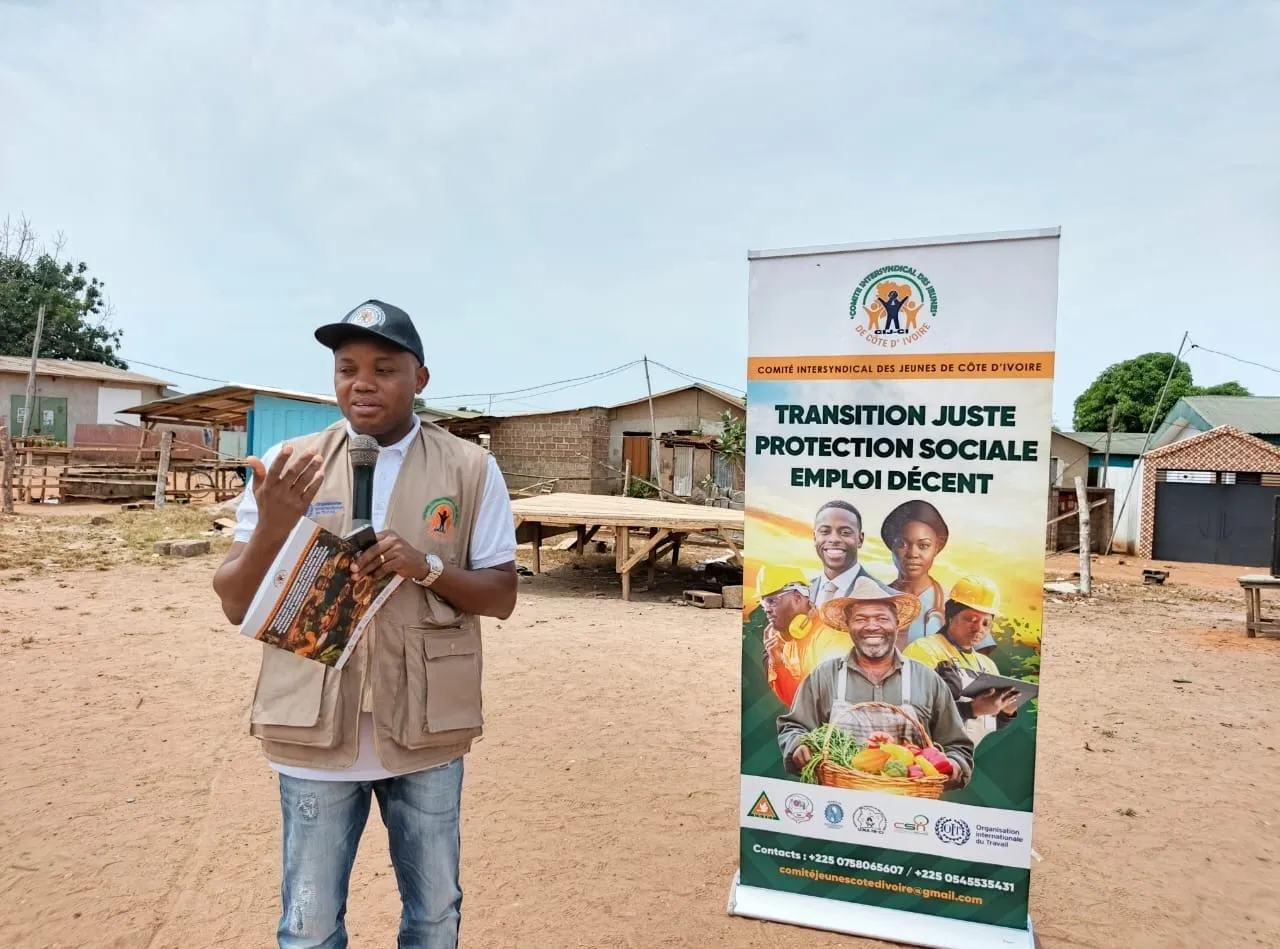Dofra Sekongo, membre du Comité intersyndical des jeunes de Côte d’Ivoire (CIJ-CI), micro en main, sensibilise à la transition juste et au travail décent dans l’agriculture.
