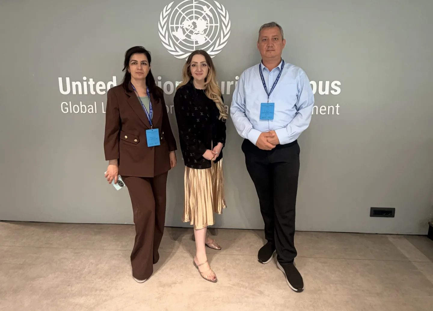 Three people stand posing for a photo