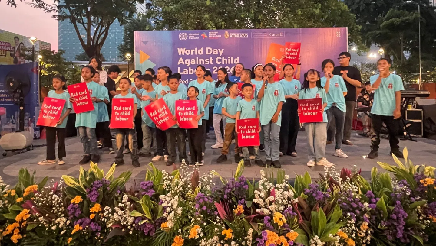 A group of children on the stage holding posters
