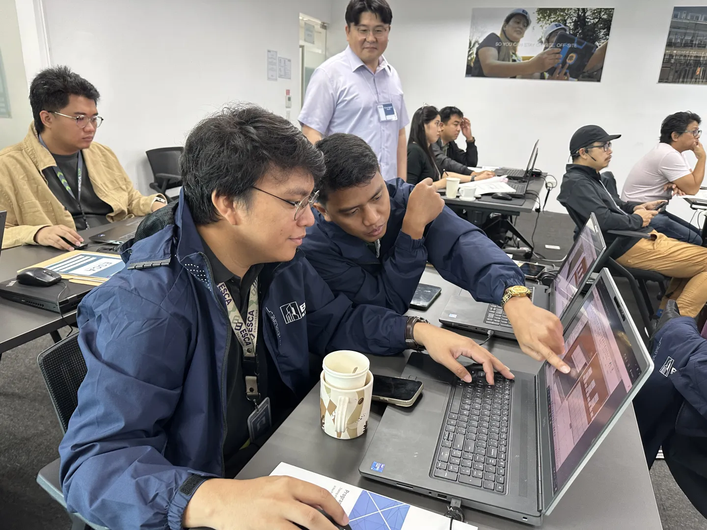 Participants work together on laptops during a hands-on BIM training session.