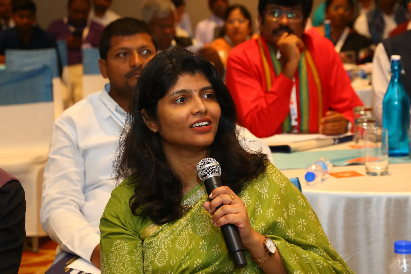 A participant holds a microphone while speaking