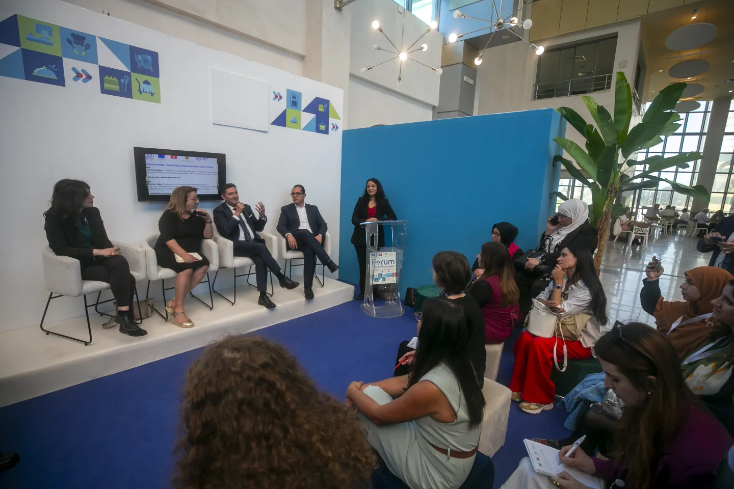 Des intervenants échangent avec un public de jeunes lors d’une session organisée dans l’Espace Pitching du Forum tuniso-européen de l’Hôtellerie & de la Restauration. Les participants suivent les présentations, prennent des notes et assistent aux échanges consacrés aux perspectives d’emploi et de développement des compétences dans le secteur.