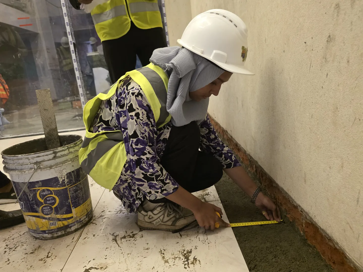 Marzan at work on a construction site, applying the skills she gained through her training
