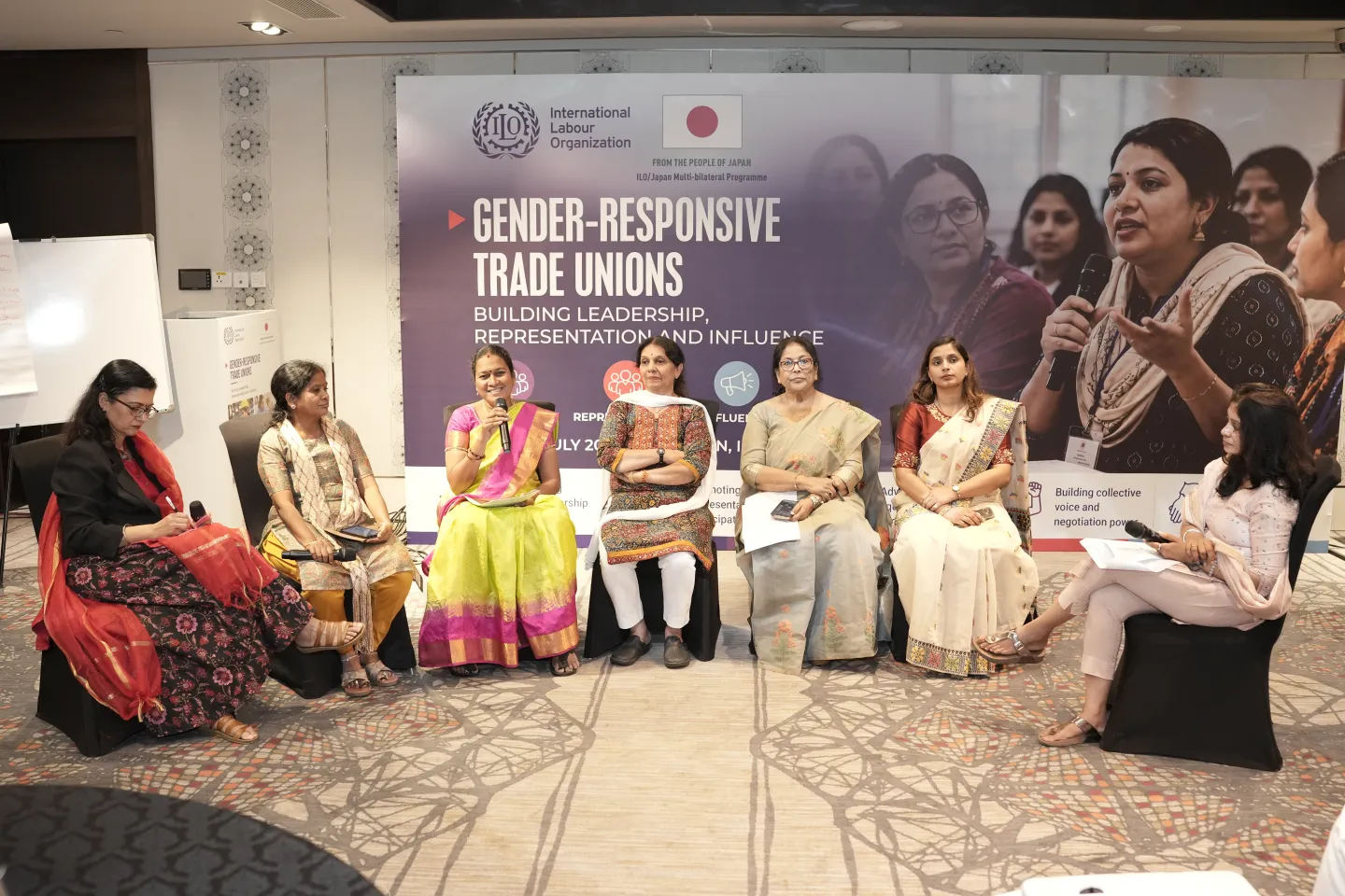 Seven women sit in a panel discussion.