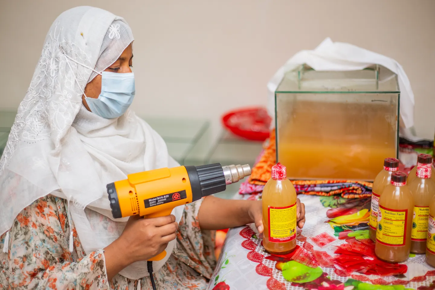 Reshma Akhter preparing vinegar bottle for selling