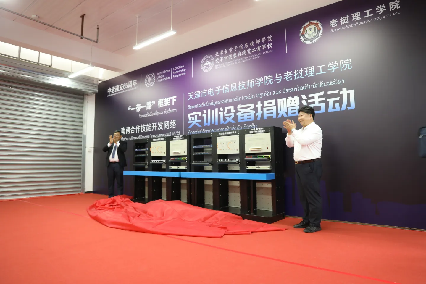 wo officials applaud beside a row of newly unveiled equipment. 