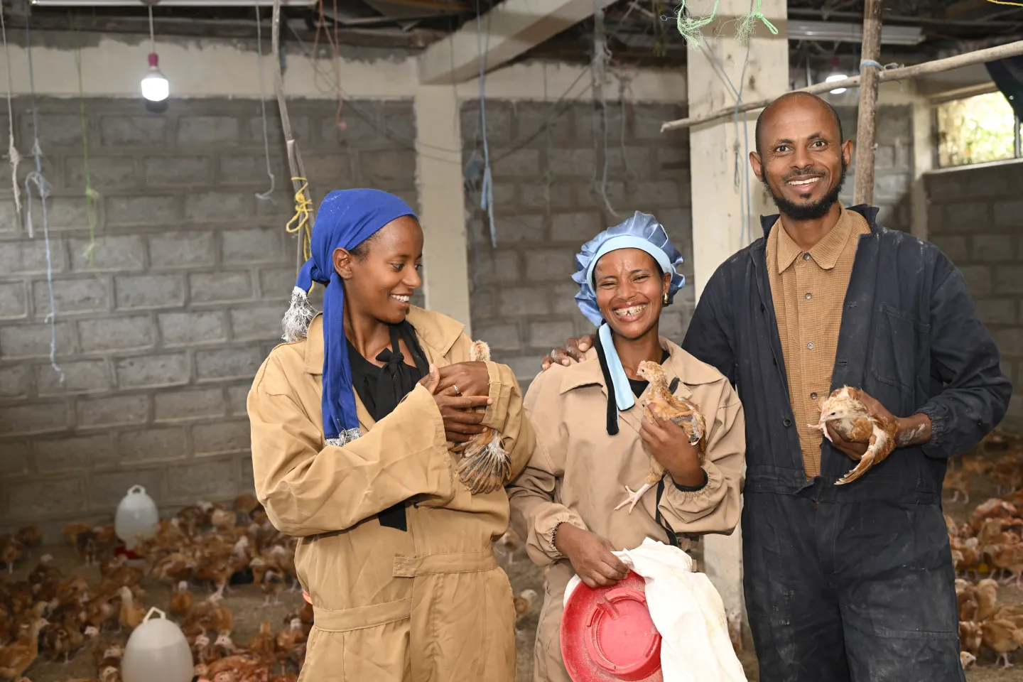 two young women and a man inside poultry farm