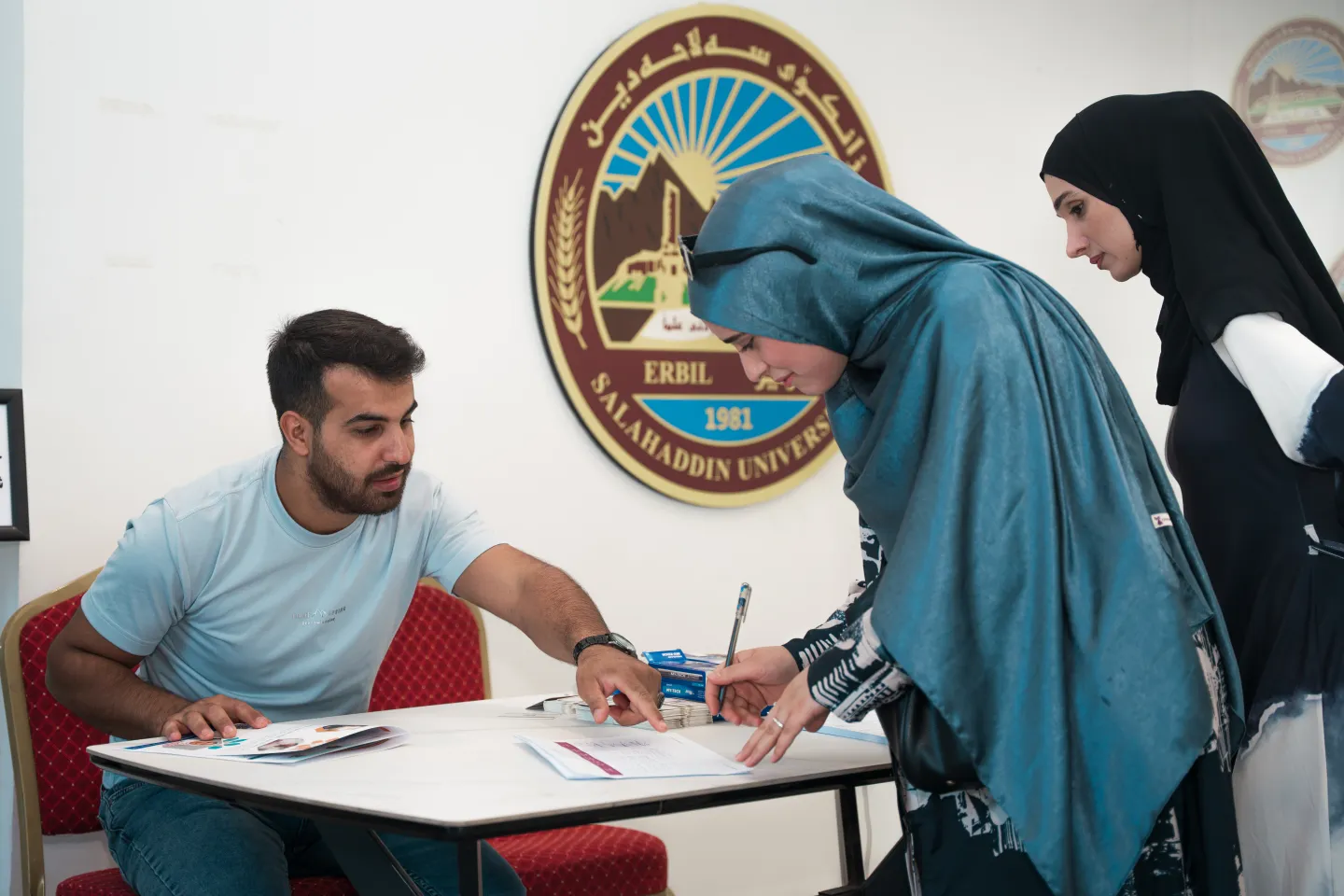 two female students signing at the registration desk 