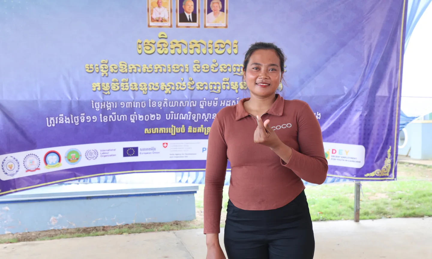 A lady standing in front of a banner. 