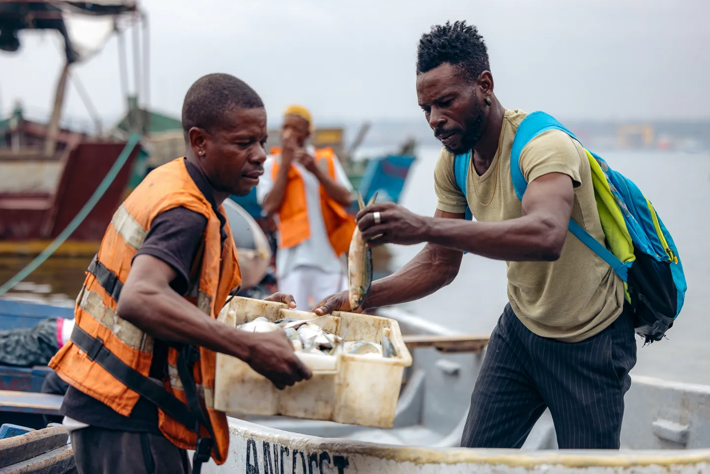 Pescador a entregar peixe no barco