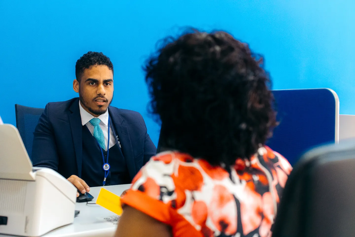 Homem de frente para uma mulher no balcão administrativo